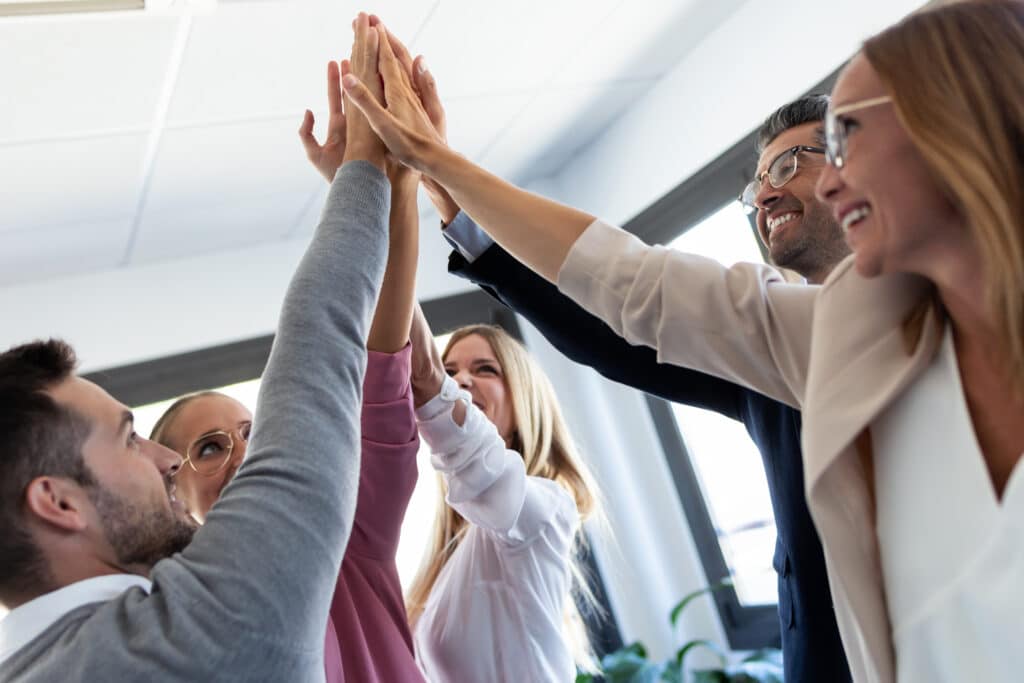 Agile success concept Group of successful young businesspeople slapping hands