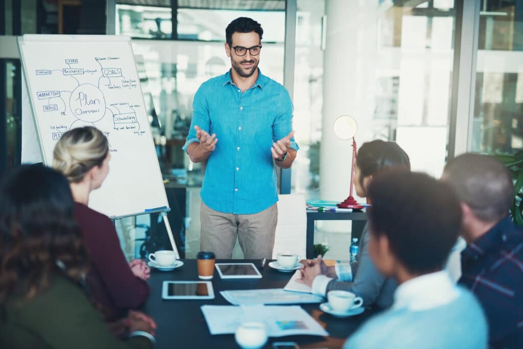 key traits of an Agile leader concept with a leader at he head of the table