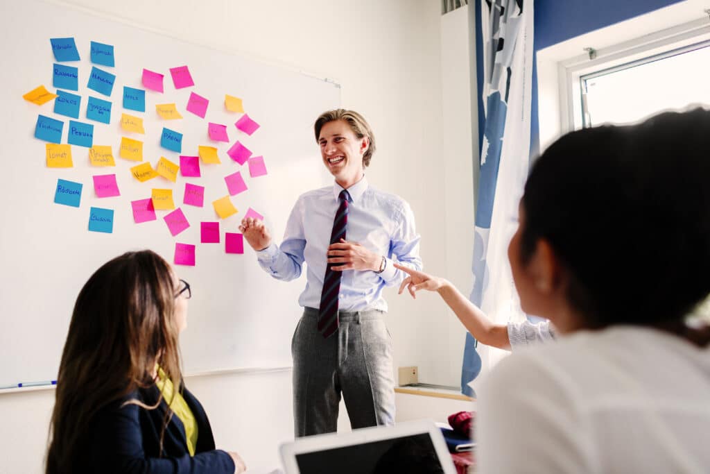 Business people with sticky notes on whiteboard