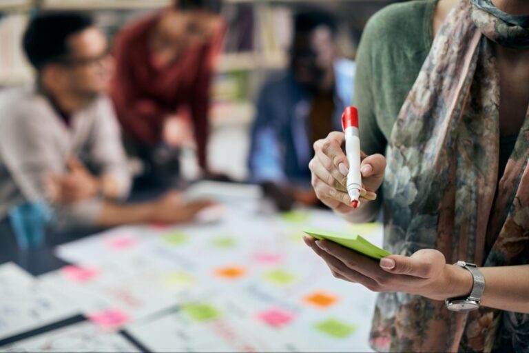 Team brainstorming creative ideas with sticky notes during a collaborative meeting.