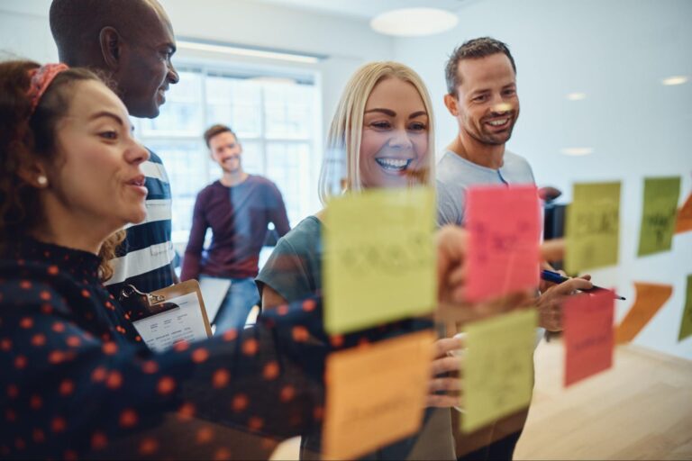 Team brainstorming session using colorful sticky notes in a modern workspace.